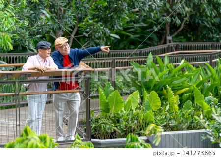 Couple Asian lover of lgbt stand together in the walkway in public park and one man point to the right and they look happiness to relax together in big city. 141273665