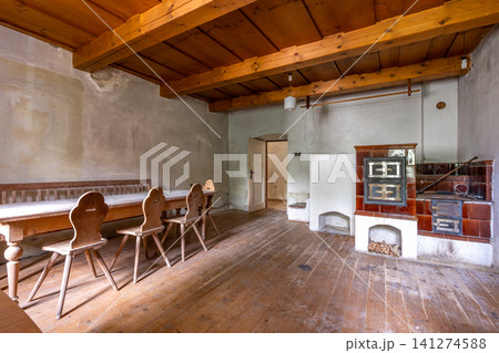 Traditional rustic room with wooden furniture and tiled stove Traditional rustic room with wooden furniture and tiled stove 141274588
