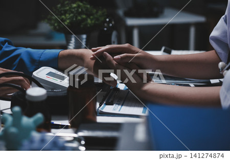 Professional Doctor Offers Comforting Support Holding a Patients Hand During Medical Consultation Professional Doctor Offers Comforting Support Holding a Patients Hand During Medical Consultation 141274874
