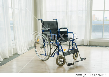 Empty wheelchair waiting for patient services in living room retirement home hospital. Chair for people with disability at home. Handicap accessible symbol. Health care medical lonely elderly sick Empty wheelchair waiting for patient services in living room retirement home hospital. Chair for people with disability at home. Handicap accessible symbol. Health care medical lonely elderly sick 141276056