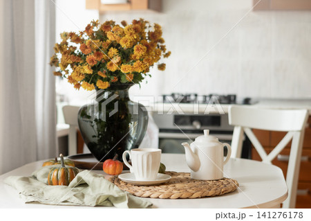 Cozy Kitchen Table with Autumn Flowers at Home Interior. Cozy Kitchen Table with Autumn Flowers at Home Interior. 141276178