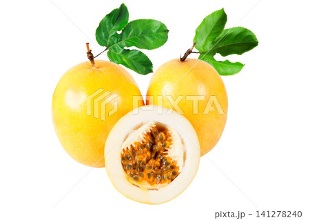 Two fresh yellow passion fruit with one sliced half showing juicy pulp and seeds, arranged with green leaves and isolated on a white background 141278240
