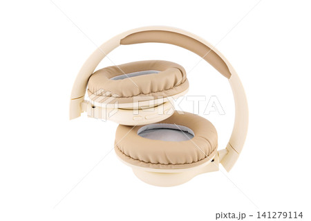beige wireless headphones in semi folded view on a white background beige wireless headphones in semi folded view on a white background 141279114