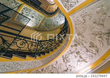 Naples, Italy - November 5, 2018, Panoramic view of antique curved staircase decorated with stucco with wrought iron railings with a floral pattern at Galleria Umberto I, without people, Naples, Italy Naples, Italy - November 5, 2018, Panoramic view of antique curved staircase decorated with stucco with wrought iron railings with a floral pattern at Galleria Umberto I, without people, Naples, Italy 141279447