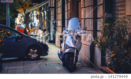 Messina, Italy - Nov 5 2018, panoramic view of one of the streets of Messina where a scooter is lonely parked along with other vehicles, the background is blurred, at daytime, Messina, Italy Messina, Italy - Nov 5 2018, panoramic view of one of the streets of Messina where a scooter is lonely parked along with other vehicles, the background is blurred, at daytime, Messina, Italy 141279449
