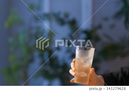 グラスに入ったお酒を持つ女性の手元 141279628