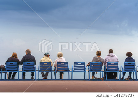Couples sitting on the bank of the sea feeding pigeons and seagulls. Couples sitting on the bank of the sea feeding pigeons and seagulls. 141279737