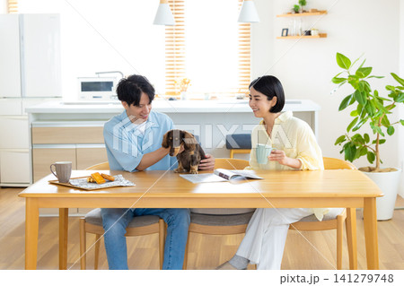 ファミリー 犬のいる暮らし リビングで愛犬と過ごす夫婦 ファミリー 犬のいる暮らし リビングで愛犬と過ごす夫婦 141279748