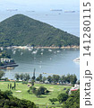 Scenic coastal landscape with a golf course and sailboats in a bay Scenic coastal landscape with a golf course and sailboats in a bay 141280115