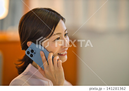 夜部屋でリラックスしてスマホを見る40代の女性 夜部屋でリラックスしてスマホを見る40代の女性 141281362