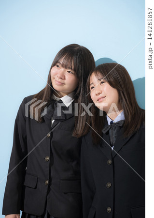 水色背景で本人女子高生や中学生2人で 仲良しで寄り添う友情や友達、仲間や親友イメージ 水色背景で本人女子高生や中学生2人で 仲良しで寄り添う友情や友達、仲間や親友イメージ 141281857