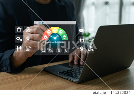 Businessman pointing at a virtual customer satisfaction gauge interface while working on a laptop, concept of business evaluation, user feedback, and service rating Businessman pointing at a virtual customer satisfaction gauge interface while working on a laptop, concept of business evaluation, user feedback, and service rating 141283824
