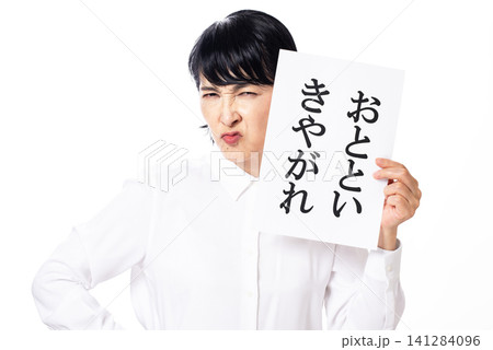 おとといきやがれと書かれた紙を持ち険しい表情の白いシャツを着た中年女性 141284096