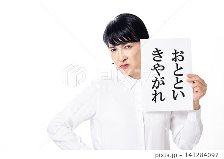 おとといきやがれと書かれた紙を持ち睨む白いシャツを着た中年女性 141284097