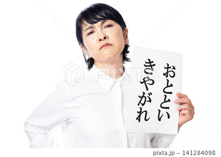 おとといきやがれと書かれた紙を持ちふんぞり返る白いシャツを着た中年女性 141284098