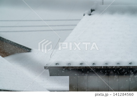 大雪が降る中で積雪した切妻屋根 大雪が降る中で積雪した切妻屋根 141284560