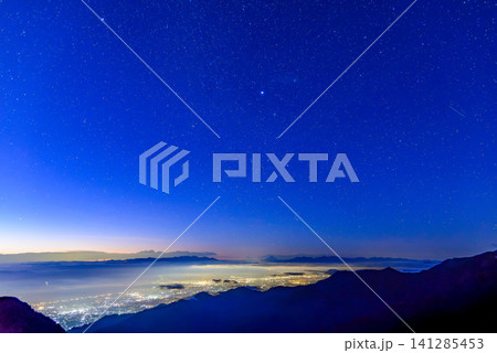 初秋の早朝 燕岳の燕山荘付近から望む星空に輝く金星と松本市街の夜景の向こうに浮かび上がる富士山のシル 初秋の早朝 燕岳の燕山荘付近から望む星空に輝く金星と松本市街の夜景の向こうに浮かび上がる富士山のシル 141285453