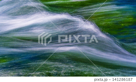 long exposure image of a river flowing through a forest long exposure image of a river flowing through a forest 141286187