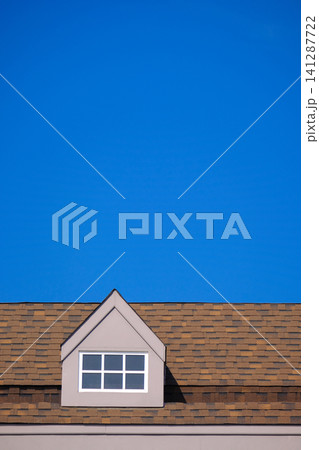 orange roof of the house with white window frame in dark blue clear sky orange roof of the house with white window frame in dark blue clear sky 141287722