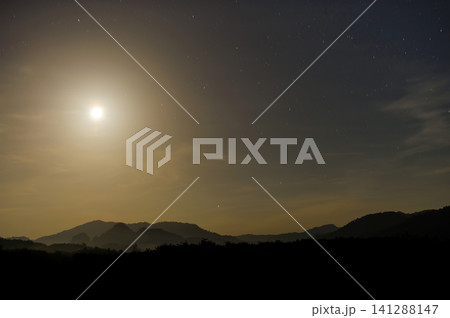 moonlight in the blue clear sky with a silhouette foreground of a forest and hill moonlight in the blue clear sky with a silhouette foreground of a forest and hill 141288147