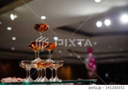 small tower of champagne's glass in wedding reception party small tower of champagne's glass in wedding reception party 141288351
