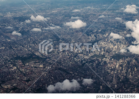 Bangkok city's bird eye view shot from a plane that flight in a morning with warming color of sunrise and some shade from clouds photo may had some noise and partly blur Bangkok city's bird eye view shot from a plane that flight in a morning with warming color of sunrise and some shade from clouds photo may had some noise and partly blur 141288366