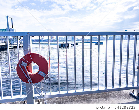 海辺のフェンスと救命浮環 夏のウォーターフロント風景 海辺のフェンスと救命浮環 夏のウォーターフロント風景 141288825
