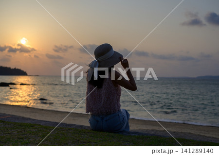 沖縄の夕焼けを眺める日本人女性の後ろ姿 沖縄の夕焼けを眺める日本人女性の後ろ姿 141289140