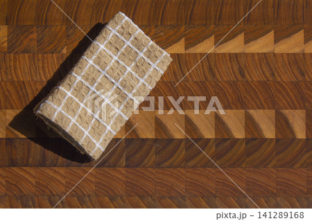 It is a cutting board and a dishcloth. It is a cutting board and a dishcloth. 141289168