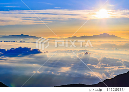 初秋の早朝 燕岳の燕山荘付近から中望遠で望む浅間山と四阿山が浮かぶ雲海に朝日が作る影の筋模様の風景 初秋の早朝 燕岳の燕山荘付近から中望遠で望む浅間山と四阿山が浮かぶ雲海に朝日が作る影の筋模様の風景 141289584