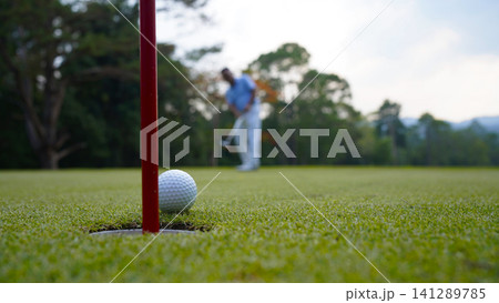 Golfers are putting golf in the evening golf course golf backglound. Golfers are putting golf in the evening golf course golf backglound. 141289785