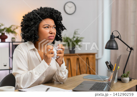 African American businesswoman crumples bill frustrated by mistake throws paper away upset at desk 141290259