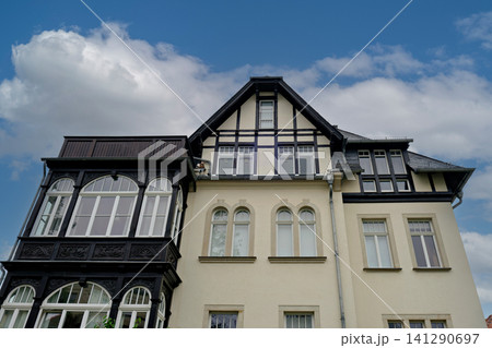 Architectural detail of a historic European residential building facade with an ornate wooden bay window 141290697