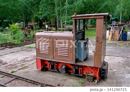 Vintage small diesel switcher locomotive with open cabin at a railway yard Vintage small diesel switcher locomotive with open cabin at a railway yard 141290725
