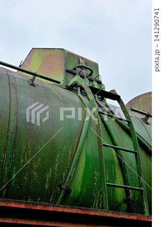 Rusty metal ladder on a mossy green vintage steam train boiler tank Rusty metal ladder on a mossy green vintage steam train boiler tank 141290741