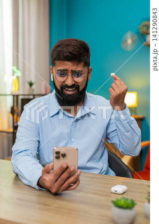 Indian man angrily removes headphones slams on table after smartphone fight big frustration reaction Indian man angrily removes headphones slams on table after smartphone fight big frustration reaction 141290843
