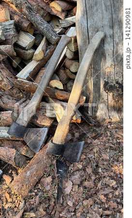 Rustic Axes and Firewood Stack in Golden Sunlight 141290981