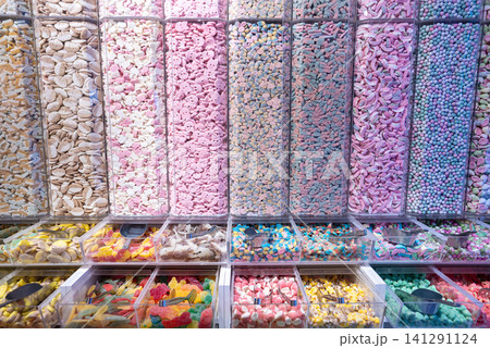 showcase of candy shop, transparent container with various sweets, marshmallow, jelly, chewy gums, rich sugar assortment 141291124