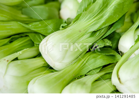 People selecting fresh vegetables and tomatoes in a market stall People selecting fresh vegetables and tomatoes in a market stall 141291485