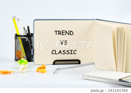Notebook sits open on a bright white surface showcasing text about choosing between modern trends and timeless classic styles while surrounded by colorful stationery supplies Notebook sits open on a bright white surface showcasing text about choosing between modern trends and timeless classic styles while surrounded by colorful stationery supplies 141291764
