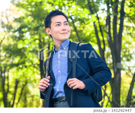 リュックを背負い公園を歩く男性 リュックを背負い公園を歩く男性 141292447