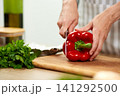 Woman hands cutting red bell pepper on wooden board 141292500