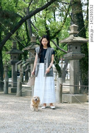石灯籠が並ぶ神社の参道を愛犬と散歩する笑顔の女性 石灯籠が並ぶ神社の参道を愛犬と散歩する笑顔の女性 141293532