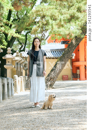神社の境内で愛犬と散歩する若い女性 神社の境内で愛犬と散歩する若い女性 141293541