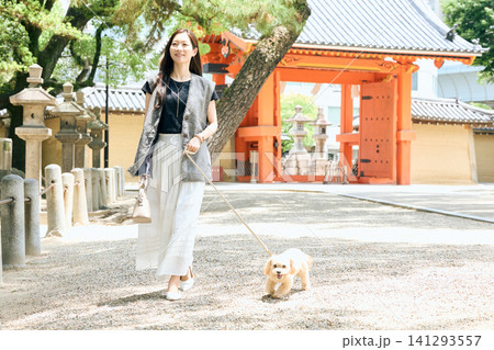神社の前で愛犬と散歩する笑顔の女性 神社の前で愛犬と散歩する笑顔の女性 141293557