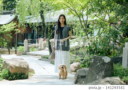 韓国風庭園を愛犬と散歩する若い女性 韓国風庭園を愛犬と散歩する若い女性 141293581