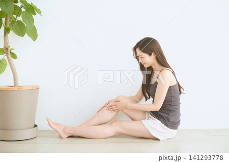 自宅で脚のスキンケアをする若い女性 自宅で脚のスキンケアをする若い女性 141293778