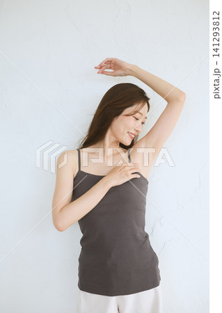 脇を見せて微笑むキャミソール姿の若い女性 脇を見せて微笑むキャミソール姿の若い女性 141293812