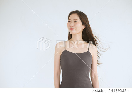白背景で髪をなびかせる黒キャミソールの若い日本人女性 白背景で髪をなびかせる黒キャミソールの若い日本人女性 141293824