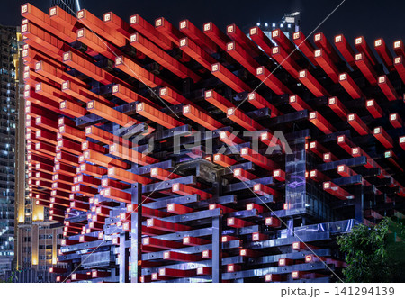 An intimate architectural detail of the Chongqing Guotai Arts Center at night, capturing the dramatic, geometric interplay of its iconic red and black beams. This avant-garde structure reinterprets An intimate architectural detail of the Chongqing Guotai Arts Center at night, capturing the dramatic, geometric interplay of its iconic red and black beams. This avant-garde structure reinterprets 141294139